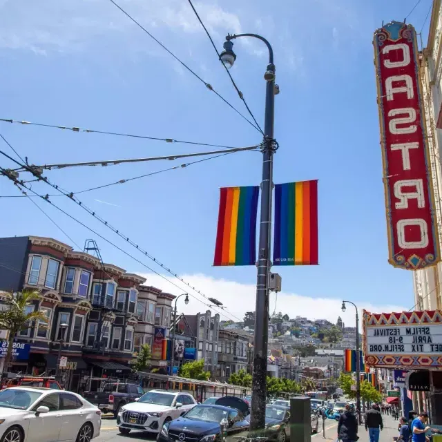 O bairro de Castro, em São Francisco, com a placa do Teatro Castro e bandeiras de arco-íris em primeiro plano.